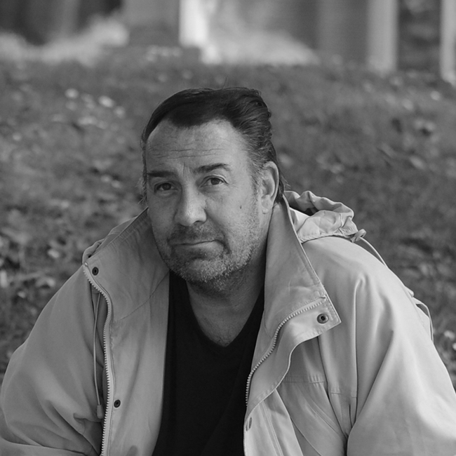 Black and white photo of a man looking at the camera. Used to illustrate a Dean's case study. This is a Shutterstock image to protect Dean's identity.