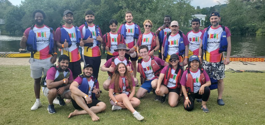 rowers in lifejackets standing on the river bank before taking part in a dragon boat race