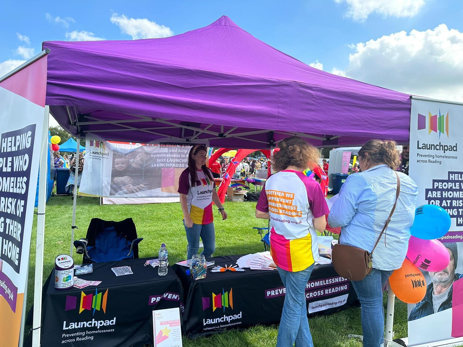 photo of people at a stall at reading Pride looking at leaflets