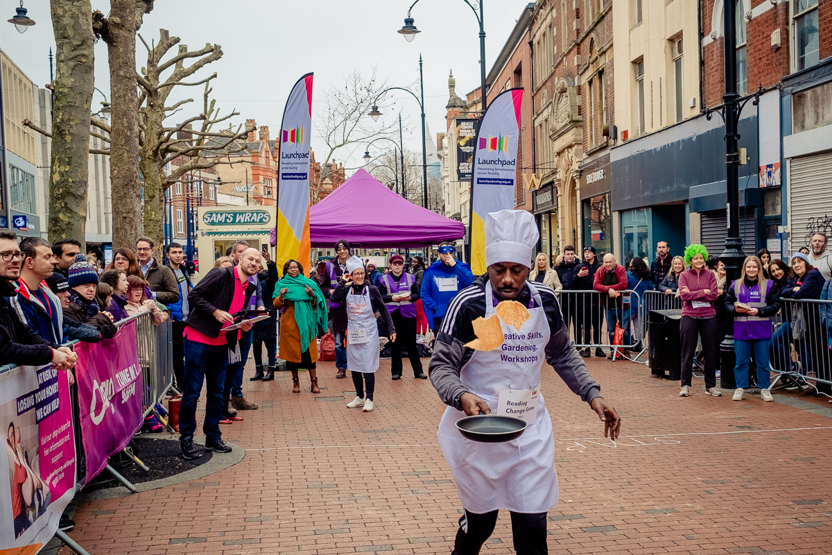 Runner taking part in the pancake race. His is wearing a chefs hat